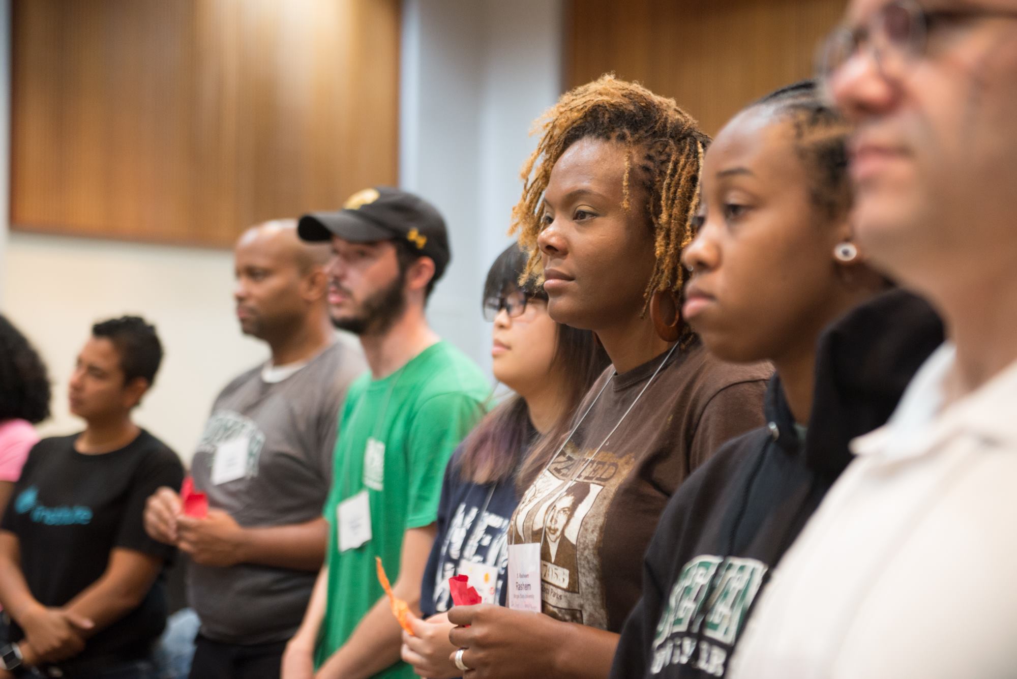 Photograph shows a group of students looking in the same direction in a classroom.