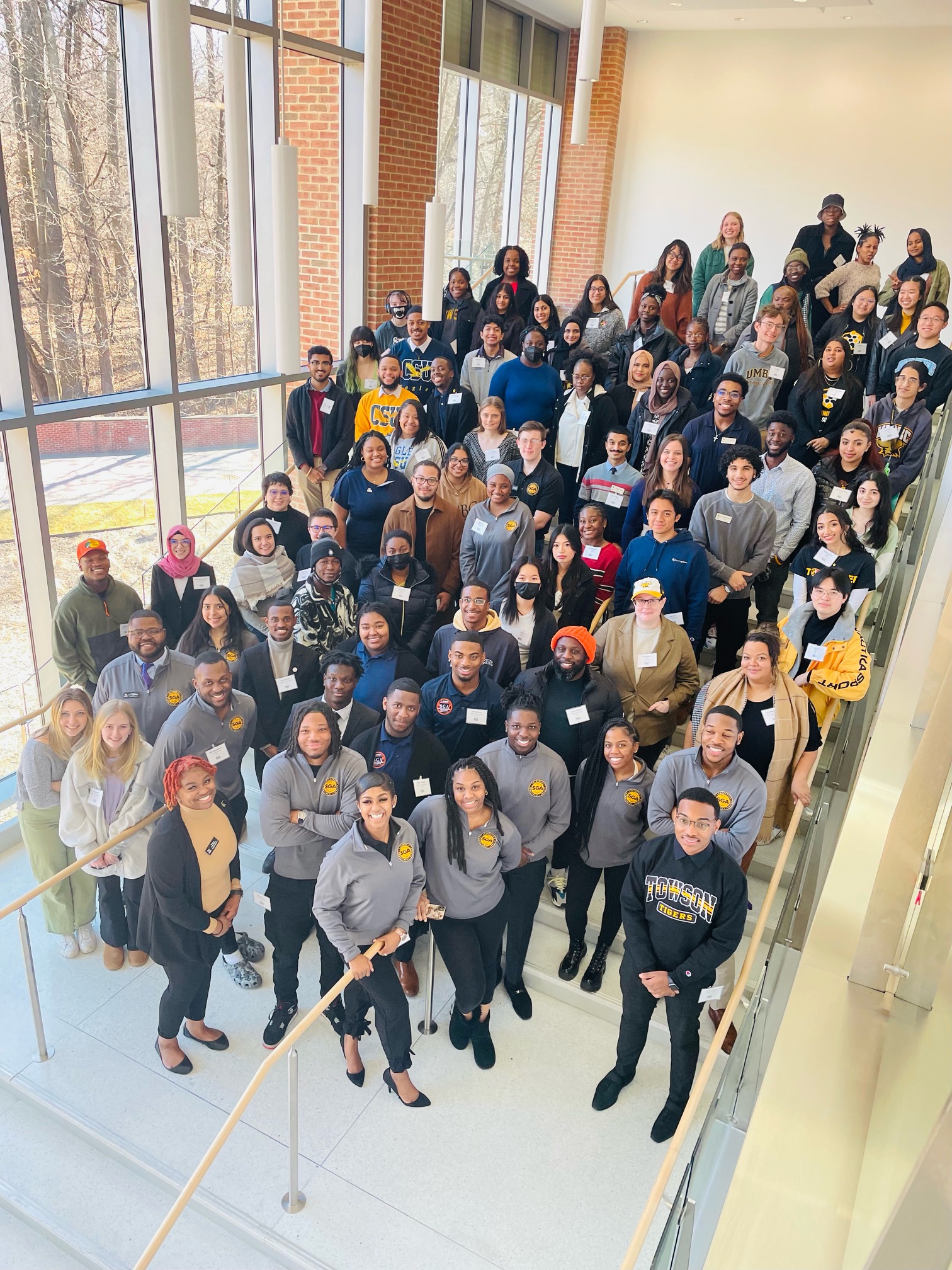 A group of people stand on stairs and pose for a photo