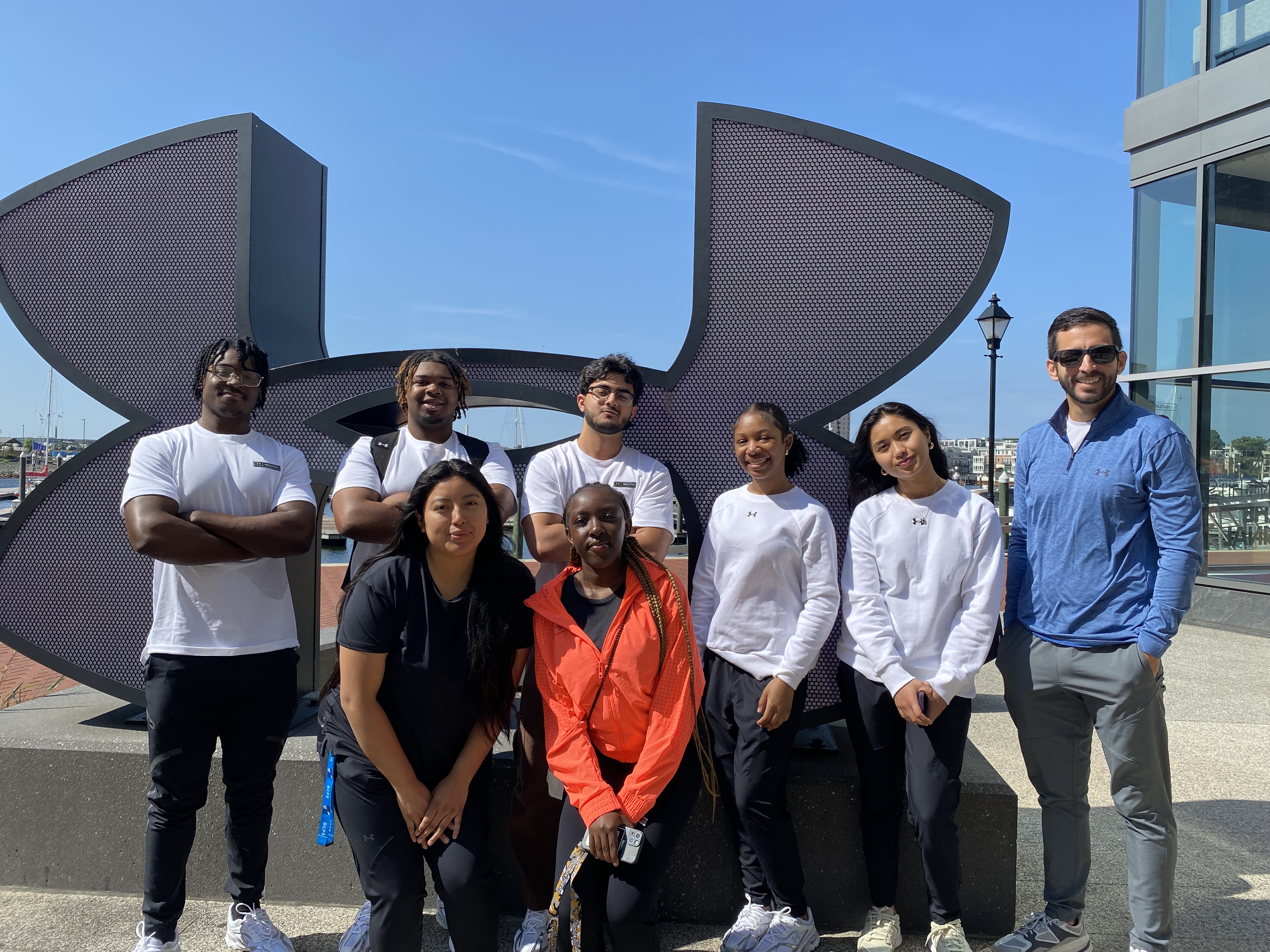 SEE Program participants from 2024 posing in front of Under Armour's logo