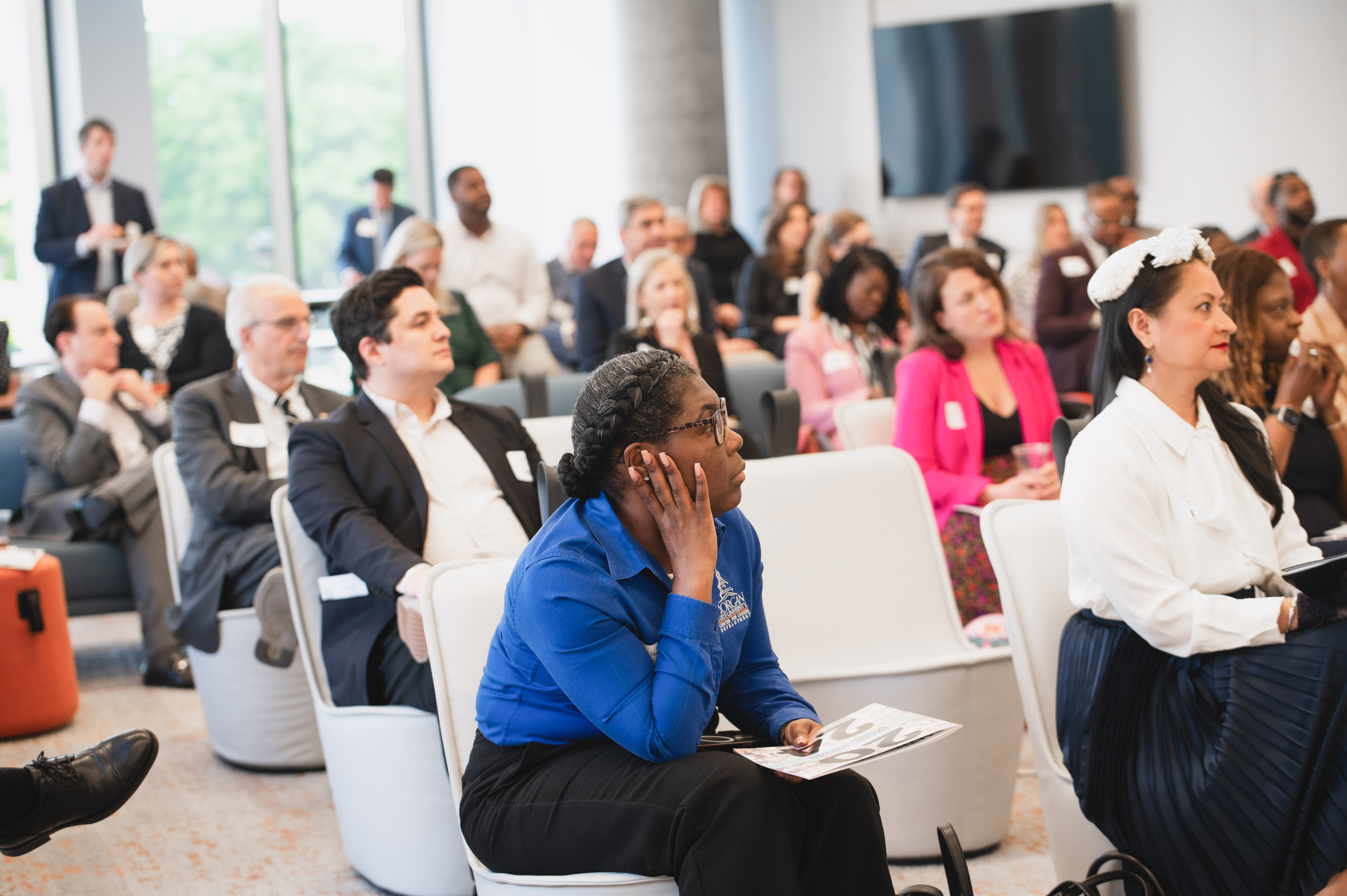 An audience of people at the 2025 Leaders in Higher Education event. Participants are eagerly listening to a roundtable discussion and facing right.