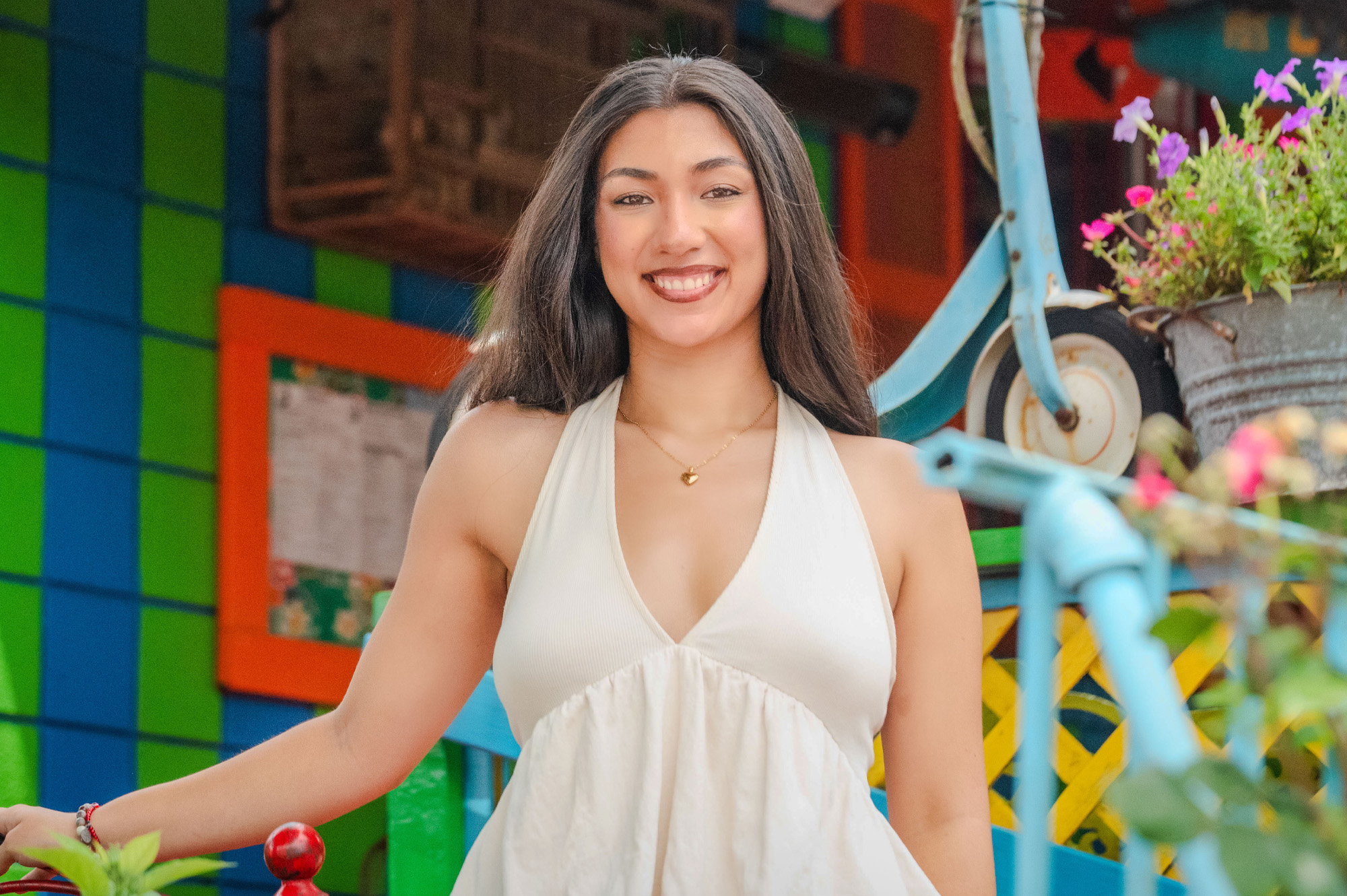 A student smiles in front of a restaurant building.