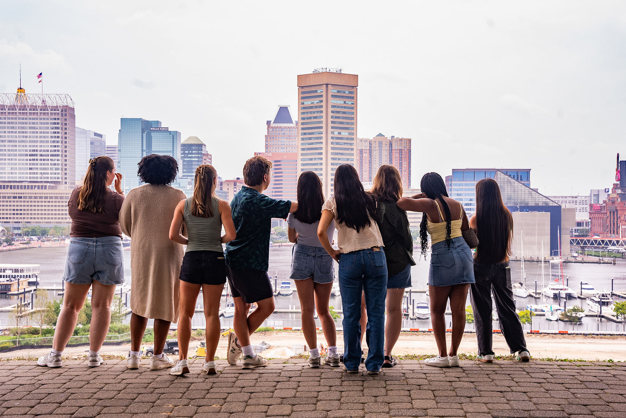 A group of students look out at the Baltimore cityscape together.