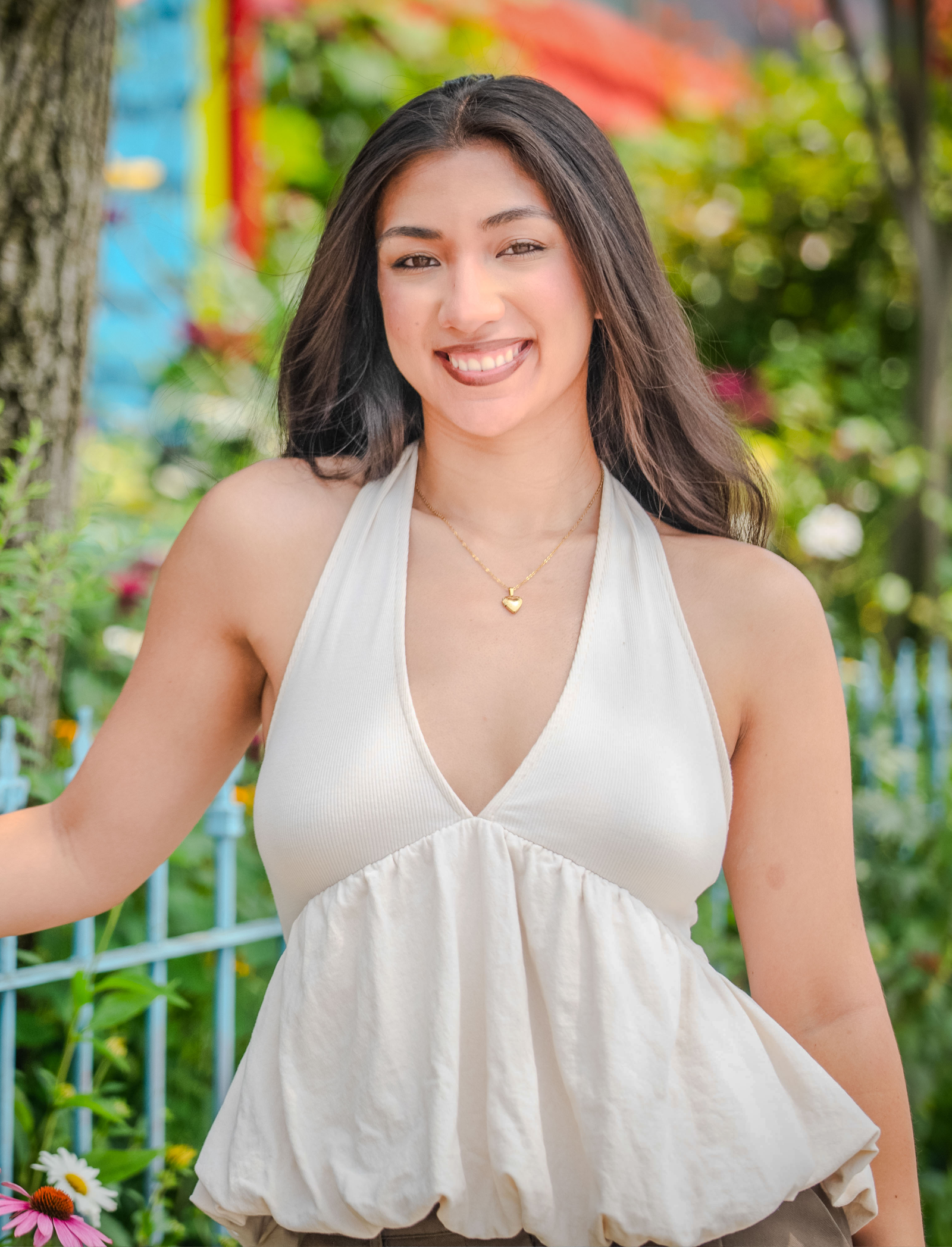 A student poses in front of a garden.